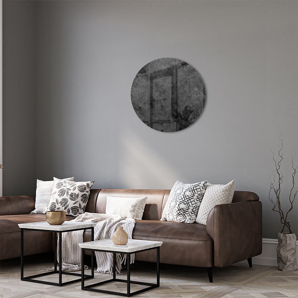 Abstract glazen schilderij in zwart en grijs aan de muur boven een houten kast.