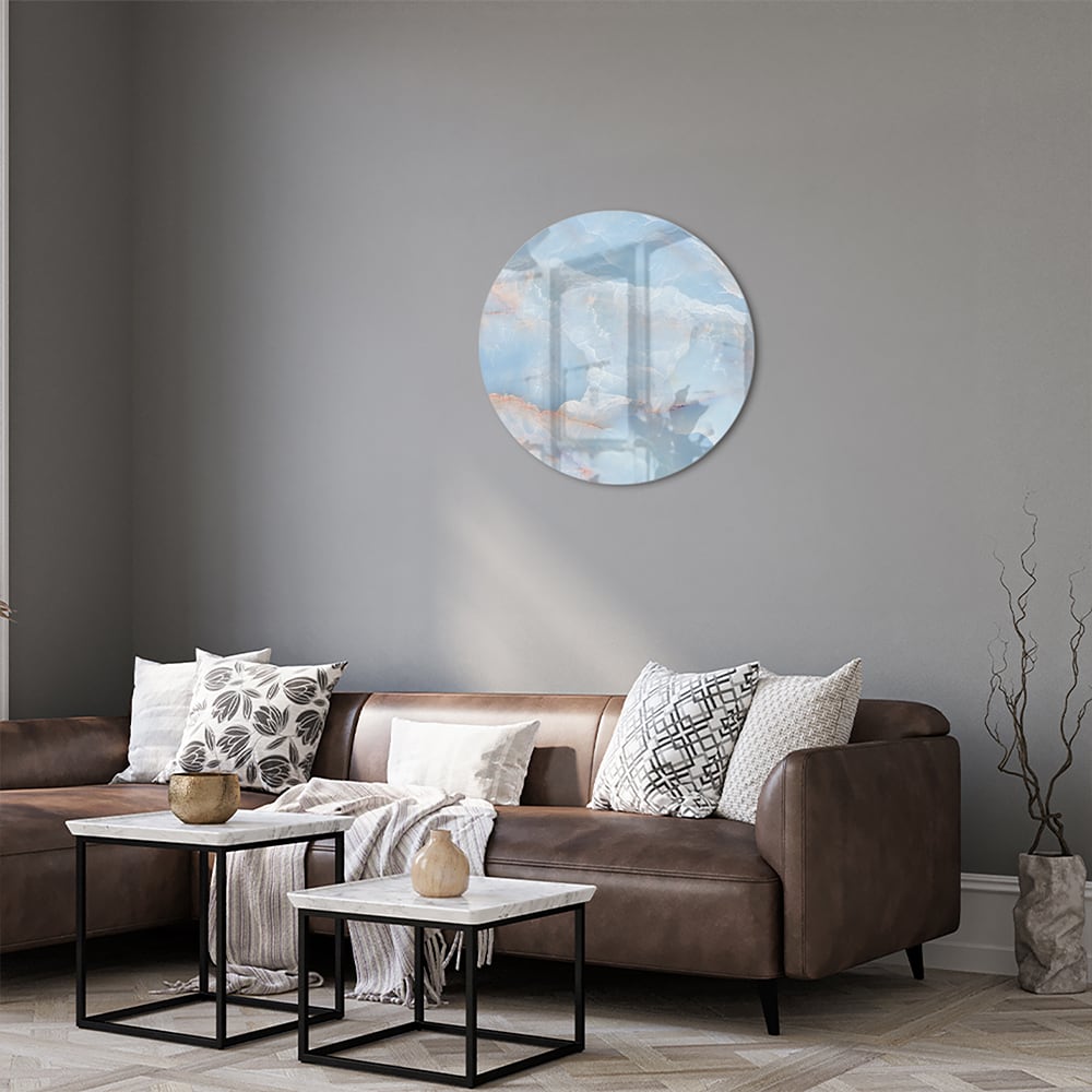 Abstract glazen schilderij in blauw en aardetinten aan de muur.