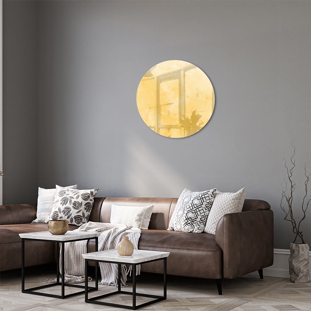 Abstract glazen schilderij in gouden tinten op een witte muur in een moderne woonkamer.