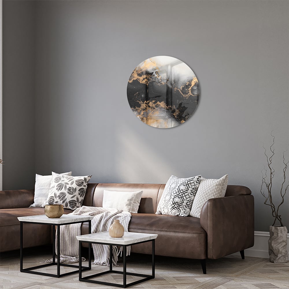 Glazen schilderij met zwarte en gouden abstracte patronen aan de muur boven een houten kast.