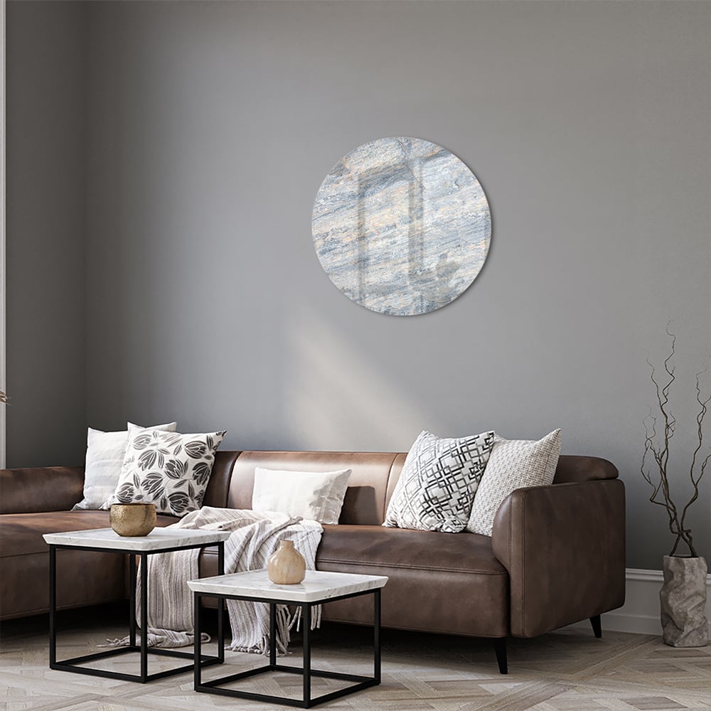 Abstract glazen schilderij met blauwe en oranje tinten aan de muur in een moderne woonkamer.