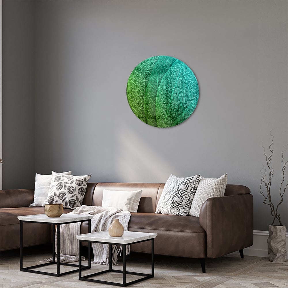 Glas schilderij met de structuur van groene bladeren aan een muur.