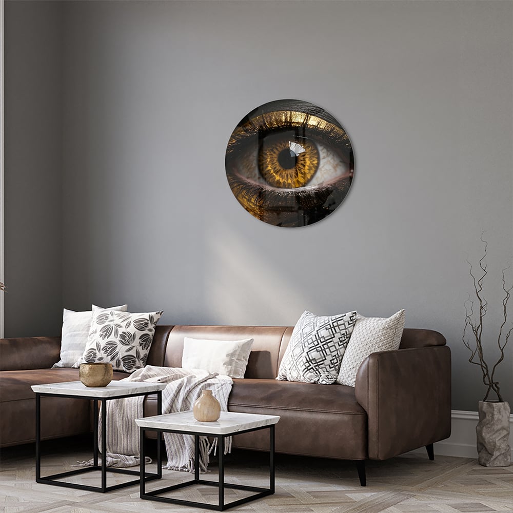 Glazen schilderij van een gouden oog op een zwarte achtergrond, hangt aan de muur.
