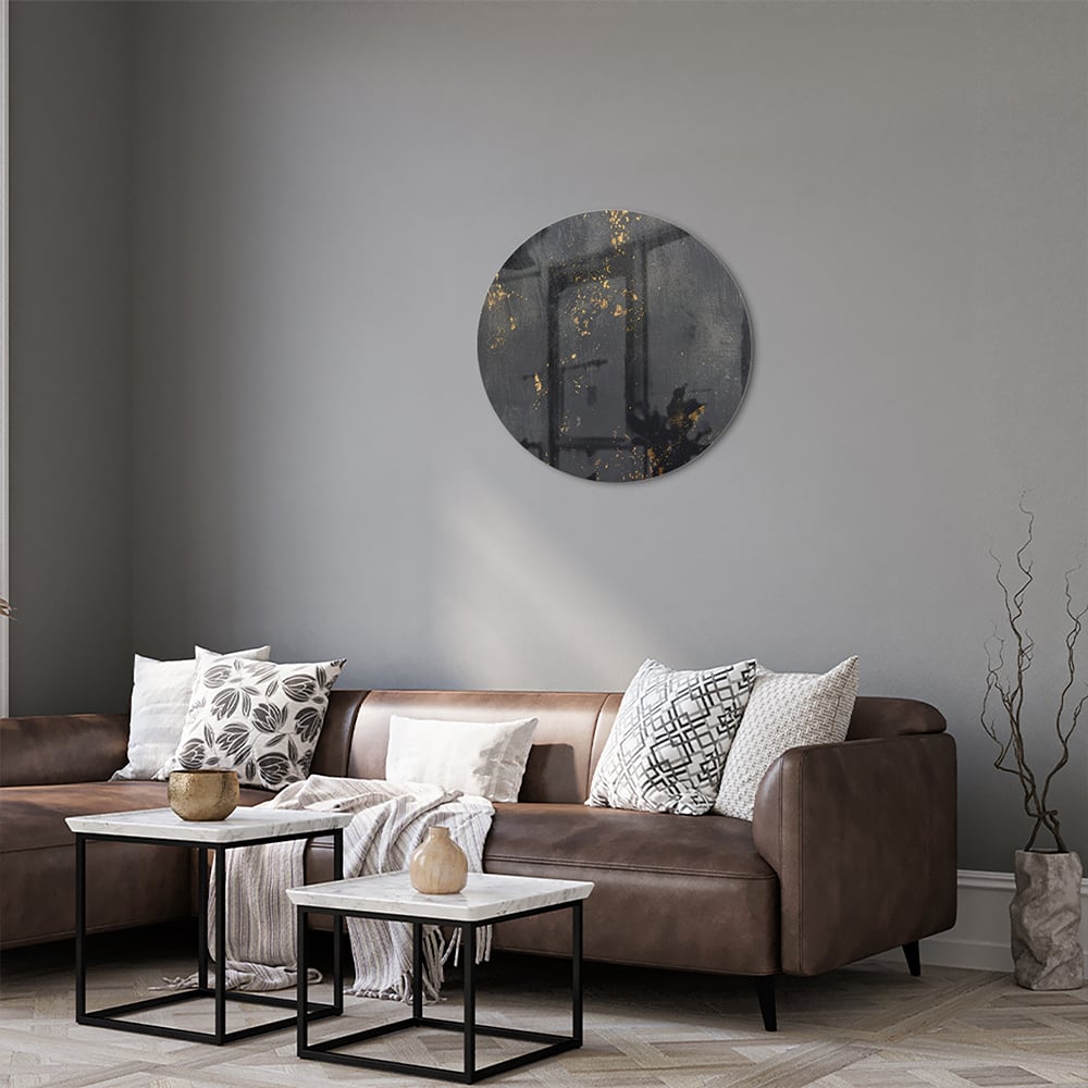 Glazen schilderij met een zwart oppervlak en gouden accenten hangt aan de muur in een moderne woonkamer.