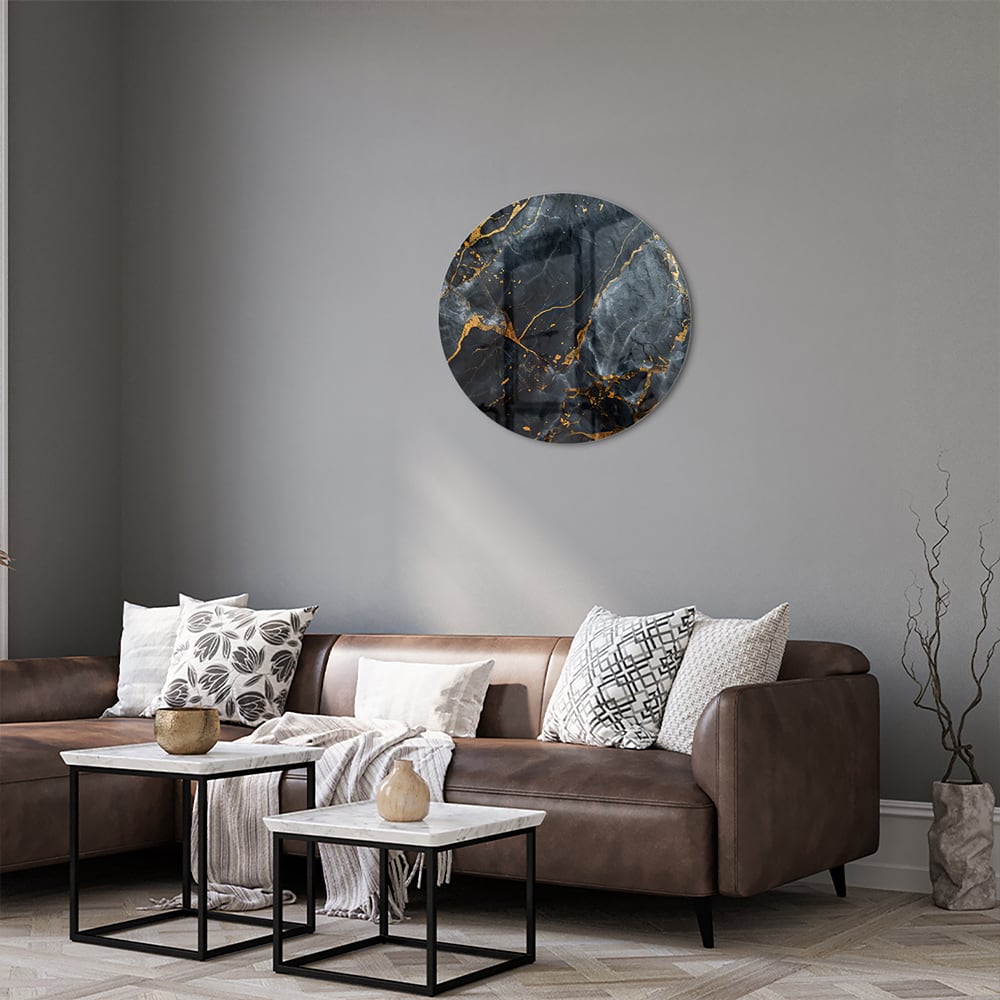 Glazen schilderij met marmerlook in zwart met gouden details aan de muur.