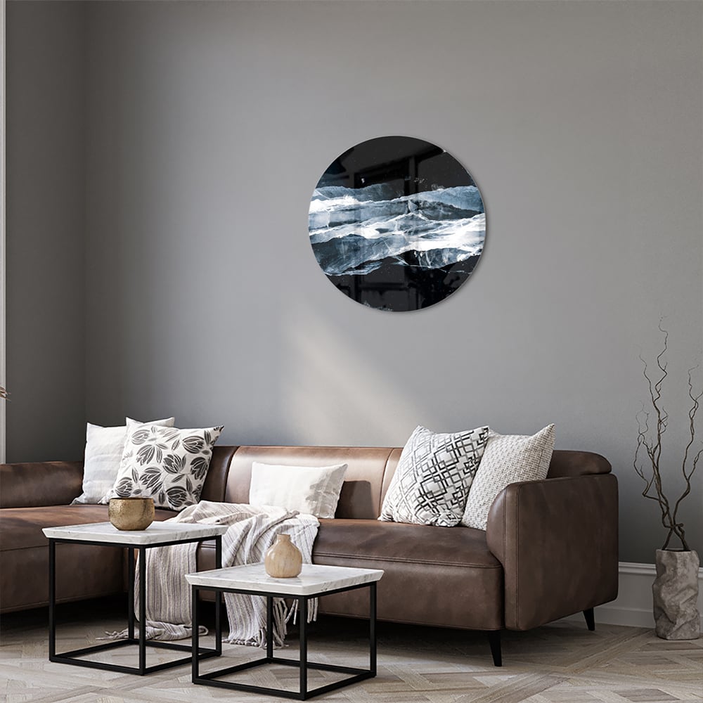 Abstract glazen schilderij in donkere kleuren met blauwe accenten, hangt aan de muur.