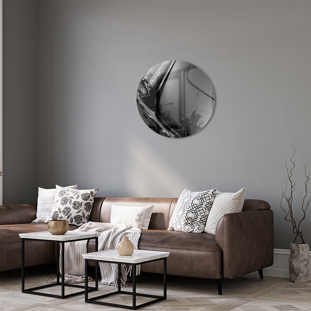 Glazen schilderij met abstracte vormen aan de muur in een stijlvolle kamer.