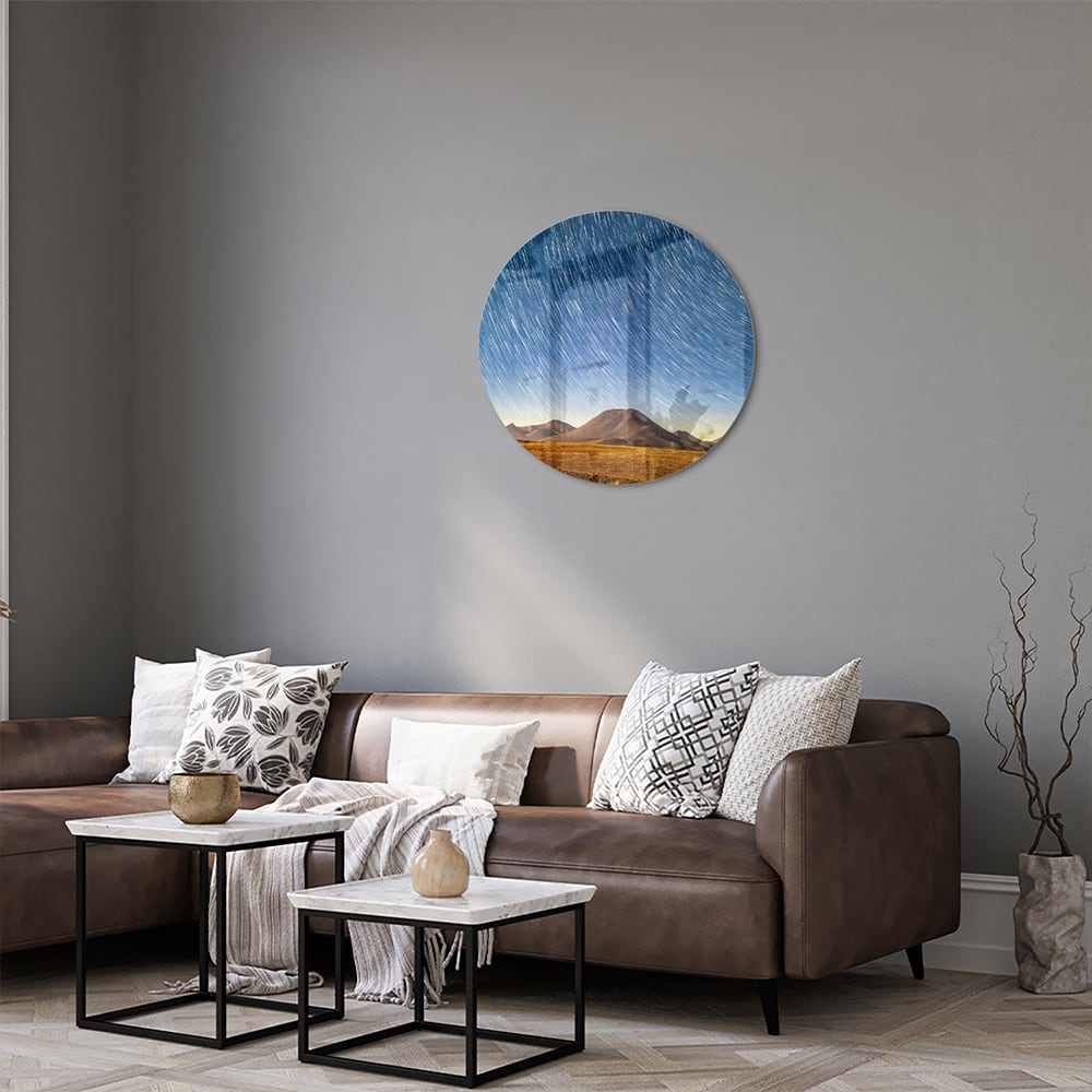 Glazen schilderij met sterrenhemel boven bergen, hangend aan de muur.