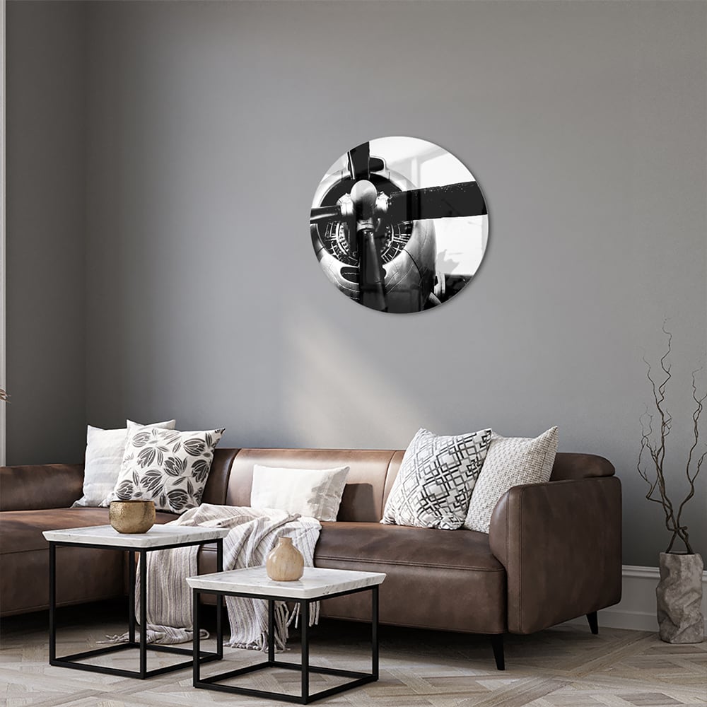 Zwart-wit glazen schilderij van een vintage vliegtuigpropeller tegen een lichte muur.