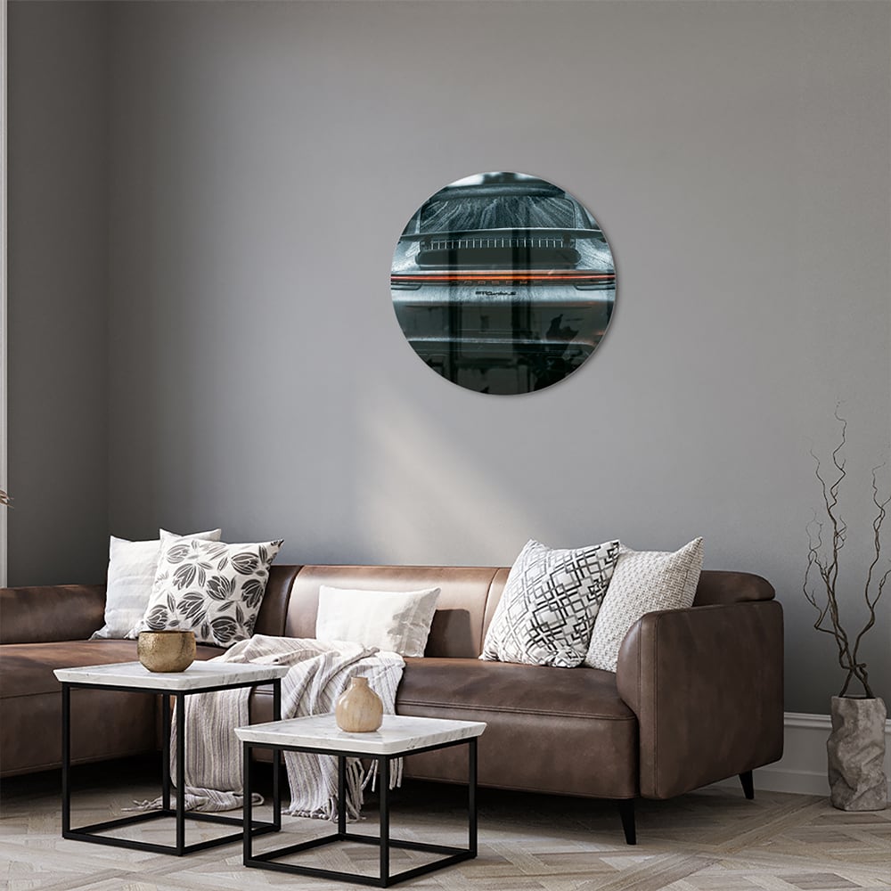 Glazen schilderij van een sportwagen aan de muur in een lichte woonkamer.