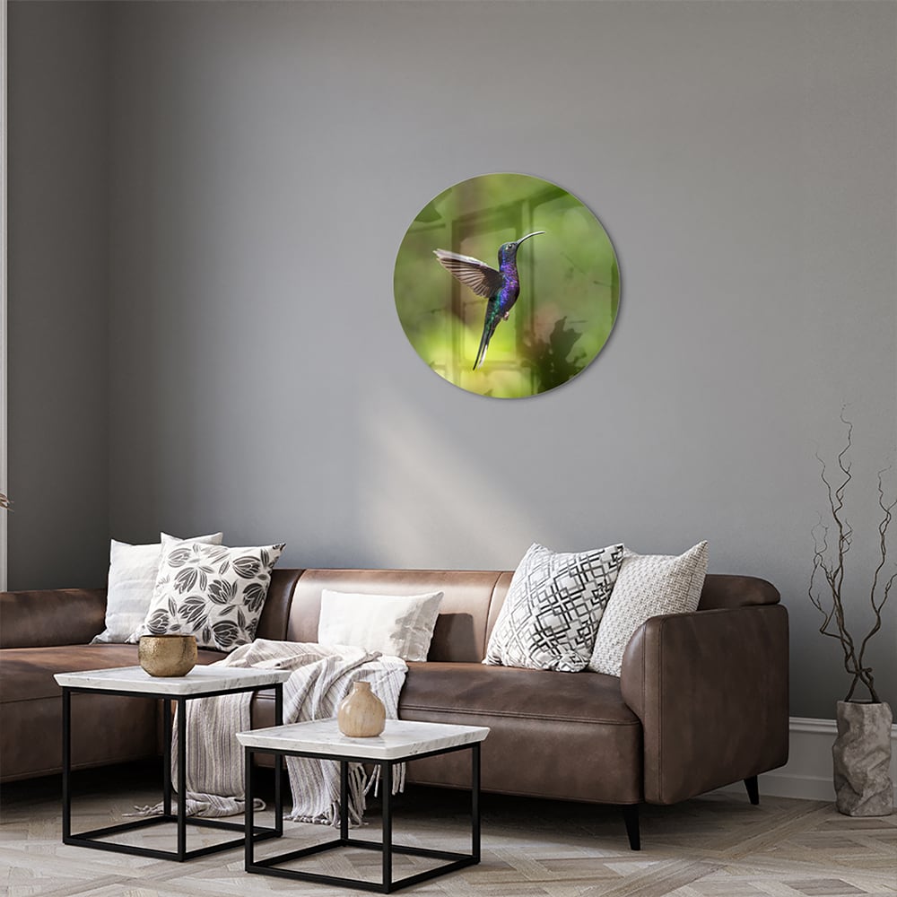 Een glazen schilderij van een kolibrie die vloog voor een groene achtergrond in een lichte kamer.